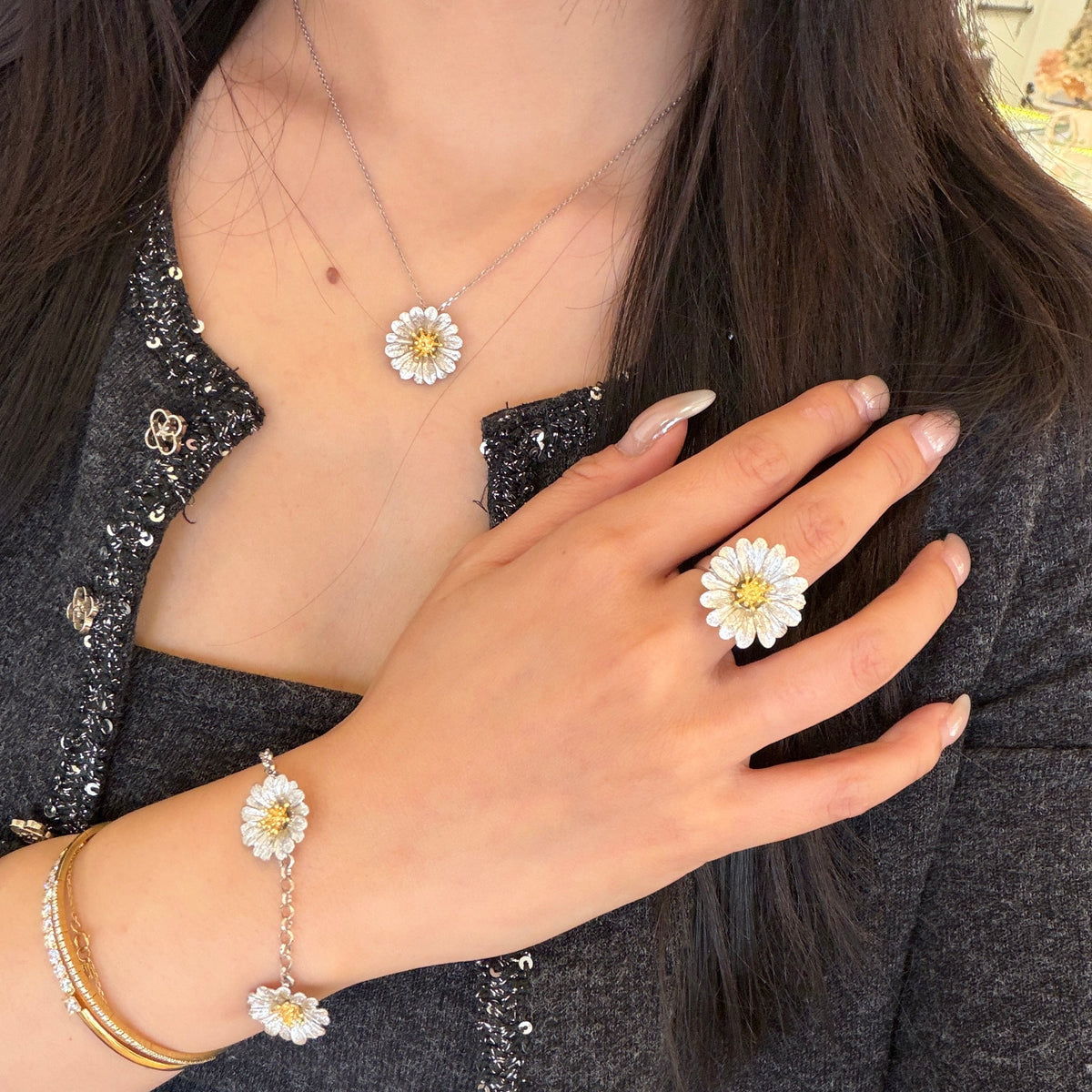 Italian silver floral bracelet featuring textured silver daisy flowers with gold-tone centers, styled with matching floral jewelry.