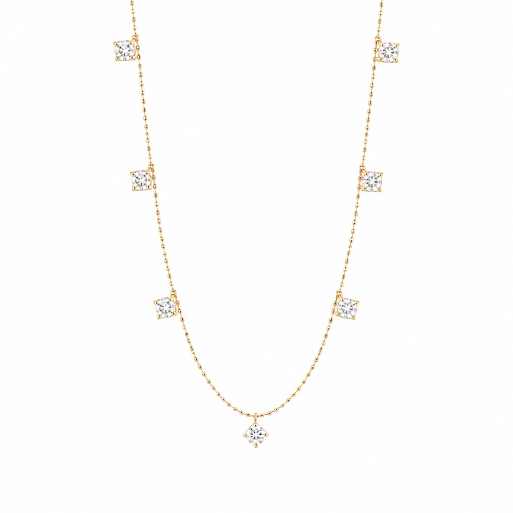 A delicate 18K yellow gold fine jewelry station necklace showcasing nine symmetrically spaced, brilliant-cut natural diamonds totaling 0.75 carats, isolated against a solid white background.