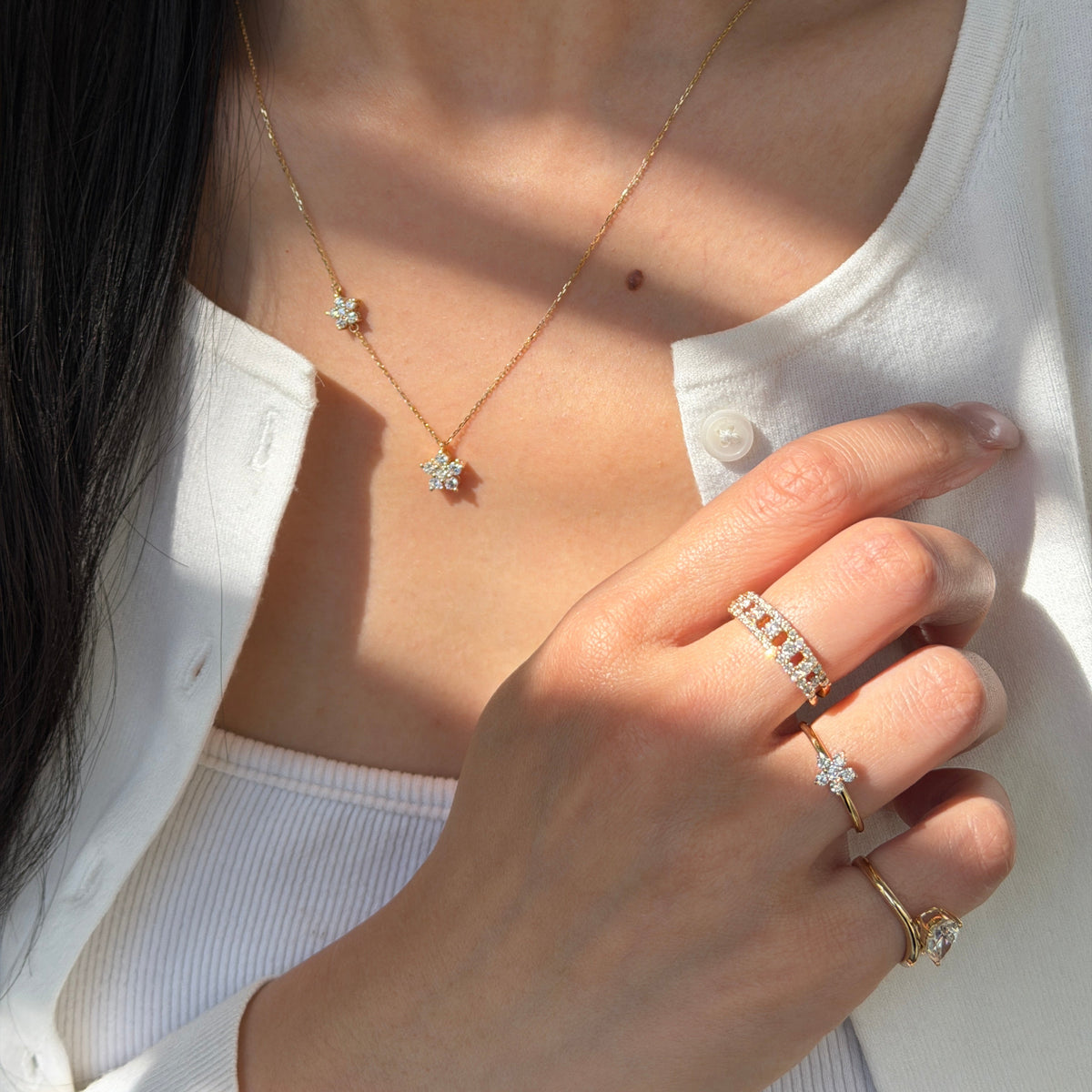 Model wearing the 18K Shimmering Steps Diamond Ring alongside the Duo-Flora Petite Necklace and Floral Ring.