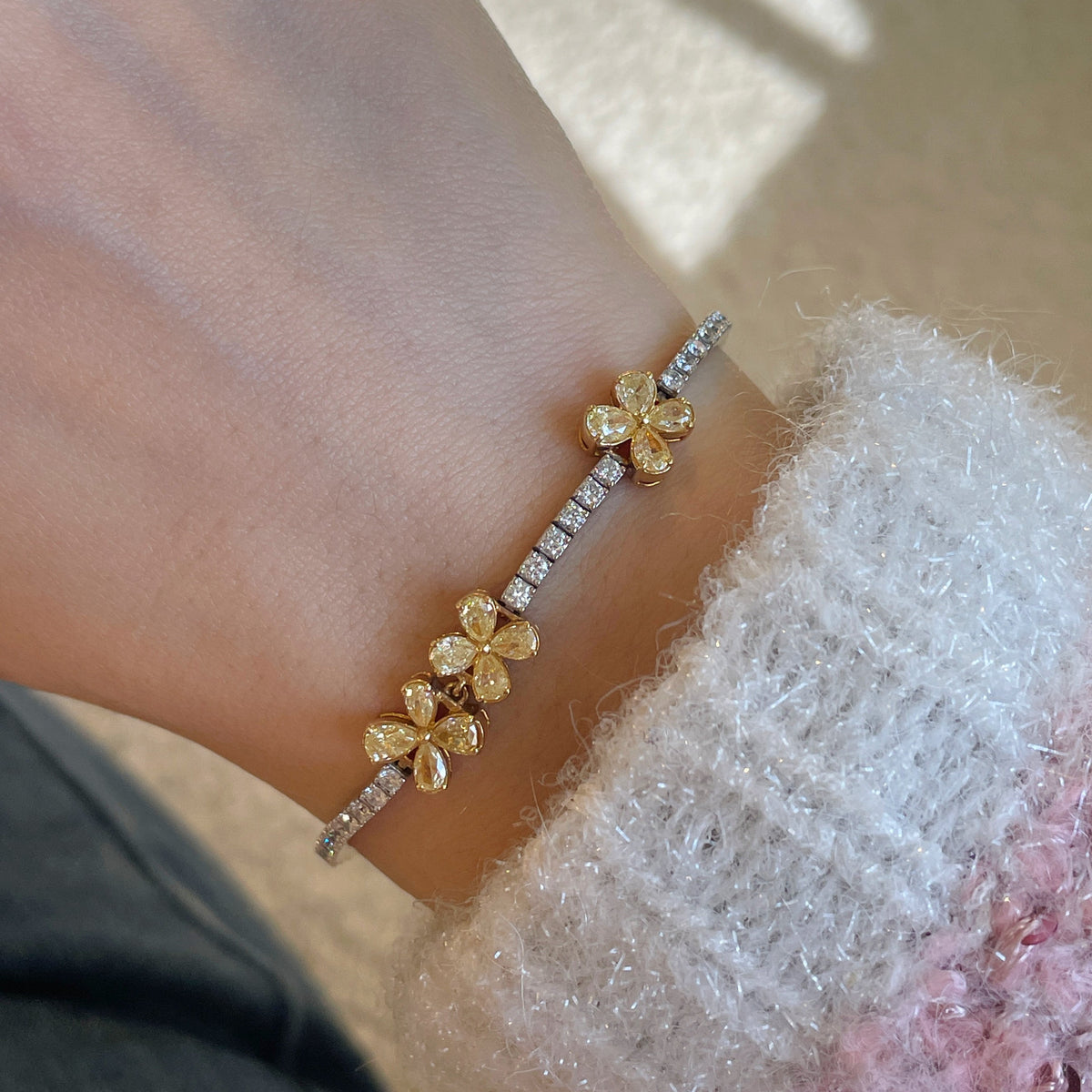 18K gold natural yellow and white diamond bracelet featuring pear-shaped yellow diamonds arranged in floral clusters with a sparkling row of white diamonds.
