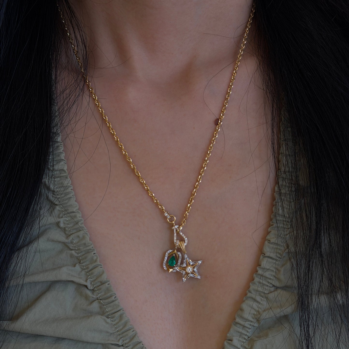 18K gold natural emerald and diamond pendant paired with an 18K gold natural diamond star pendant, styled together on a versatile 18K gold diamond chain.