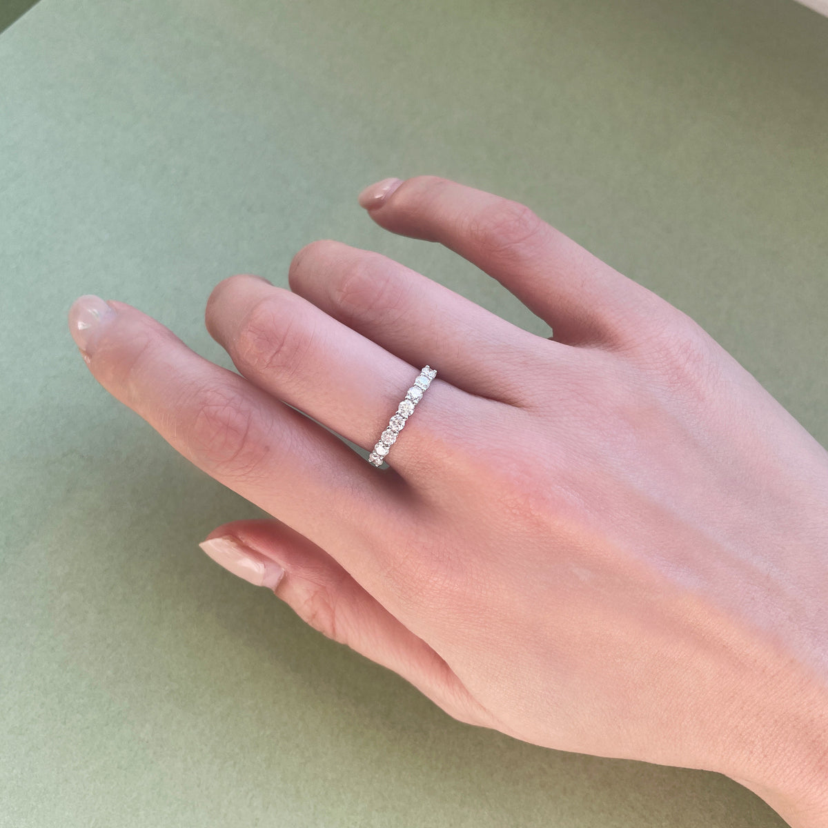 18K white gold natural diamond eternity band featuring a continuous row of sparkling round brilliant-cut diamonds, styled on the hand.