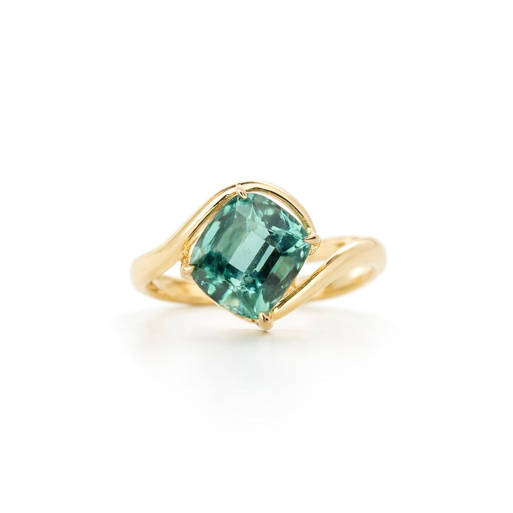 3.225 carat cushion-cut Afghan Lagoon Tourmaline ring in a modern 14K yellow gold bypass setting.