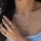 18K gold mini cross necklace featuring sparkling natural diamonds, layered with a natural diamond heart pendant and delicate diamond station chain.