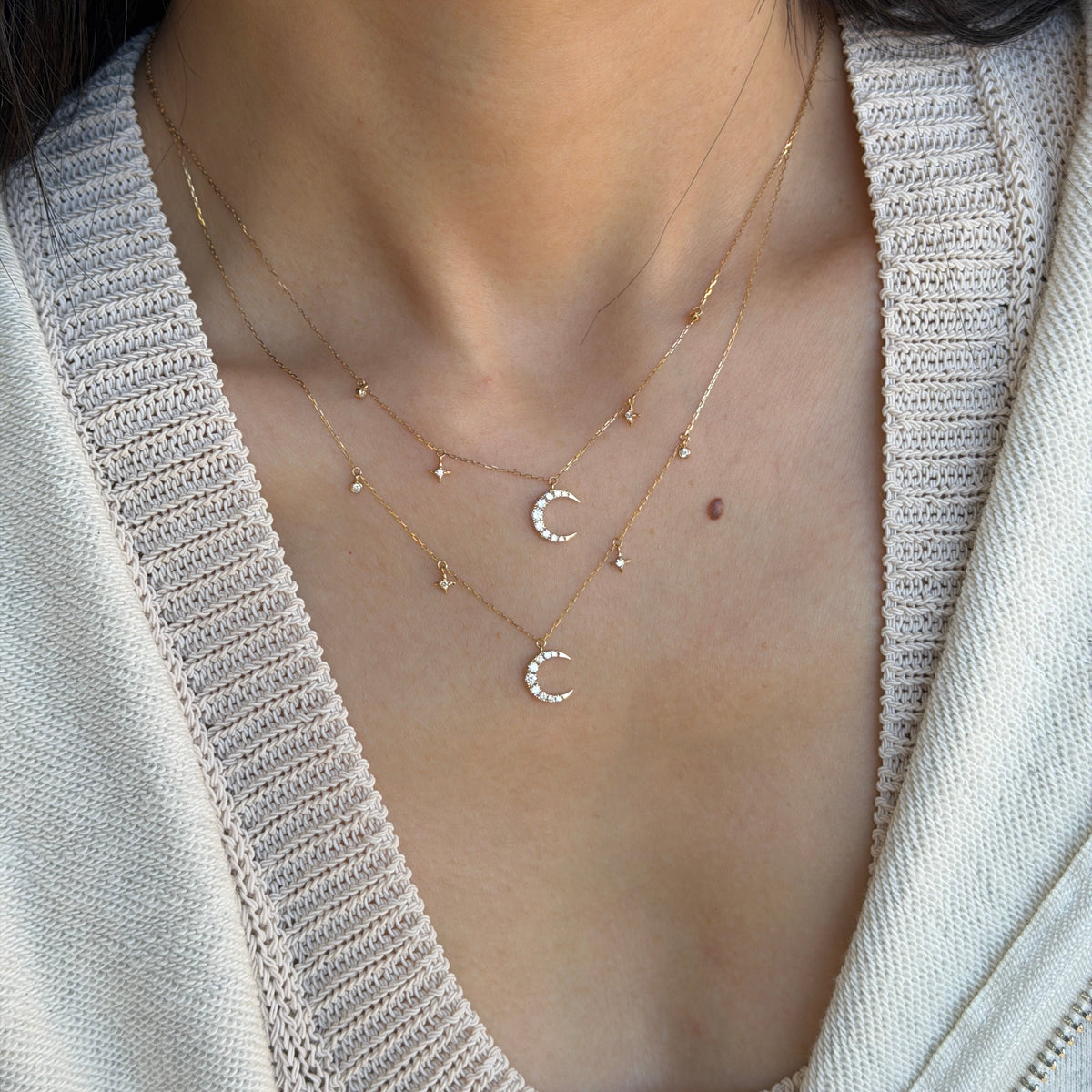 18K gold natural diamond crescent moon necklace featuring sparkling diamond-set moon pendants with delicate star and diamond accents, styled in a layered look.