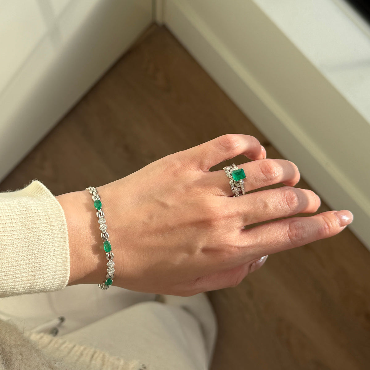 18K white gold emerald and natural diamond bracelet featuring oval-cut emeralds alternating with sparkling round brilliant-cut white diamonds in an elegant link design.