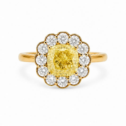 Front view of a Fantasilvia 18K yellow gold ring featuring a large cushion-cut fancy yellow diamond center stone surrounded by a flower-shaped halo of round white diamonds on a white background.
