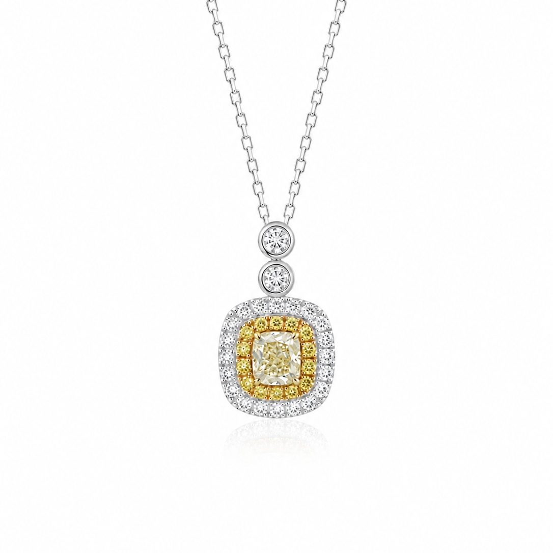 A 0.25ct natural yellow diamond pendant featuring a yellow and white diamond double halo, with two round diamond accents on the bail, suspended elegantly on an 18K white gold sparkle chain.
