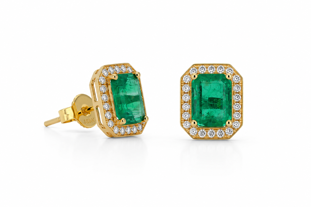 Angled studio shot of a 14K gold stud earring featuring a rectangular emerald surrounded by a lab diamond halo on a white background.