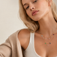 Model wearing layered 14K solid gold Spell My Stars necklaces featuring detachable diamond initial charms and natural birthstone pendants.