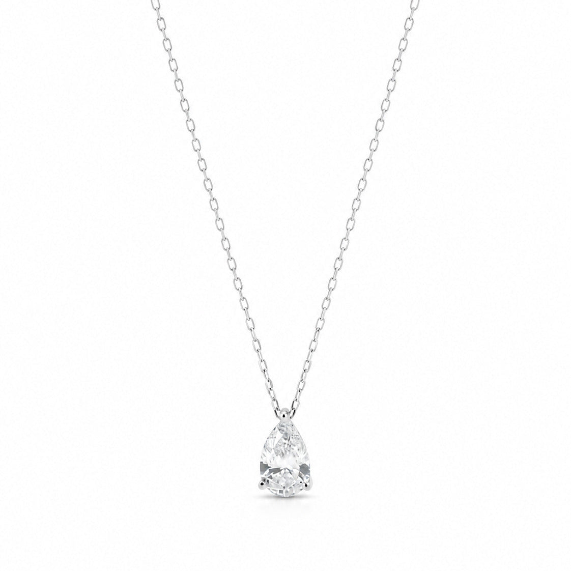 A pear-shaped diamond solitaire pendant on a delicate 18K white gold chain, centered on a white background.