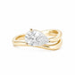 A 14K yellow gold fashion ring on a crisp white background. The ring features a prominent, brilliant pear-cut lab-grown diamond set horizontally across a high-polished gold band that splits and curves into an organic, fluid wave shape around the gemstone, perfectly proportioned for styling as a pinky ring.