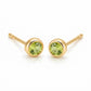 Pair of 18K yellow gold stud earrings featuring bezel-set round light green peridot gemstones.
