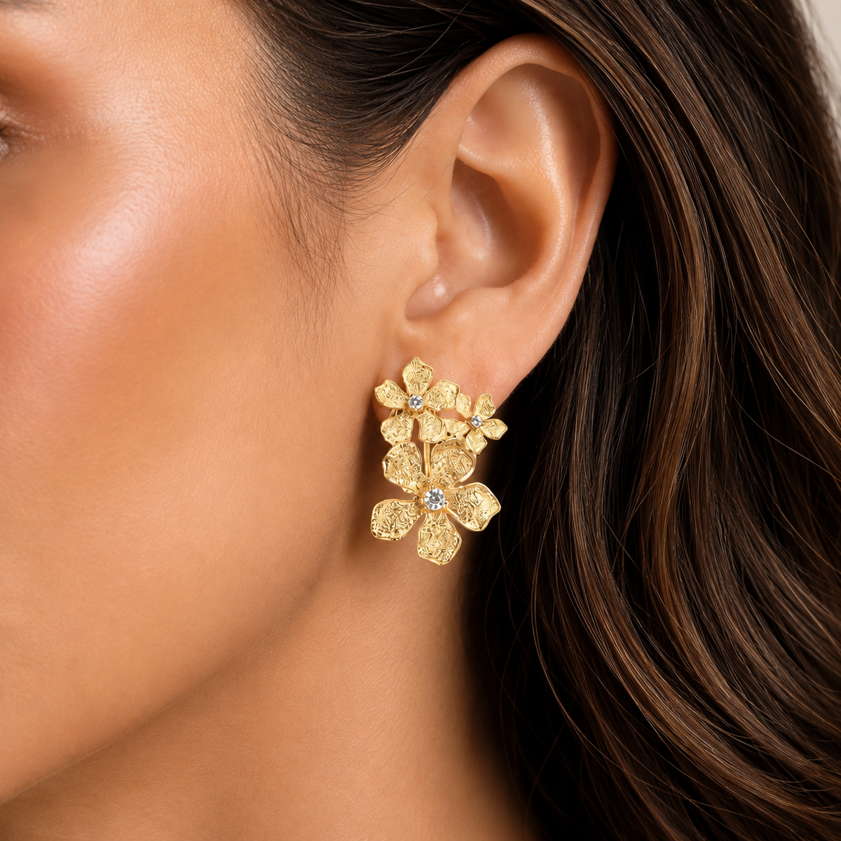Italian silver floral drop earring with a gold-tone finish, featuring textured layered flowers and sparkling crystal centers, styled on the ear.