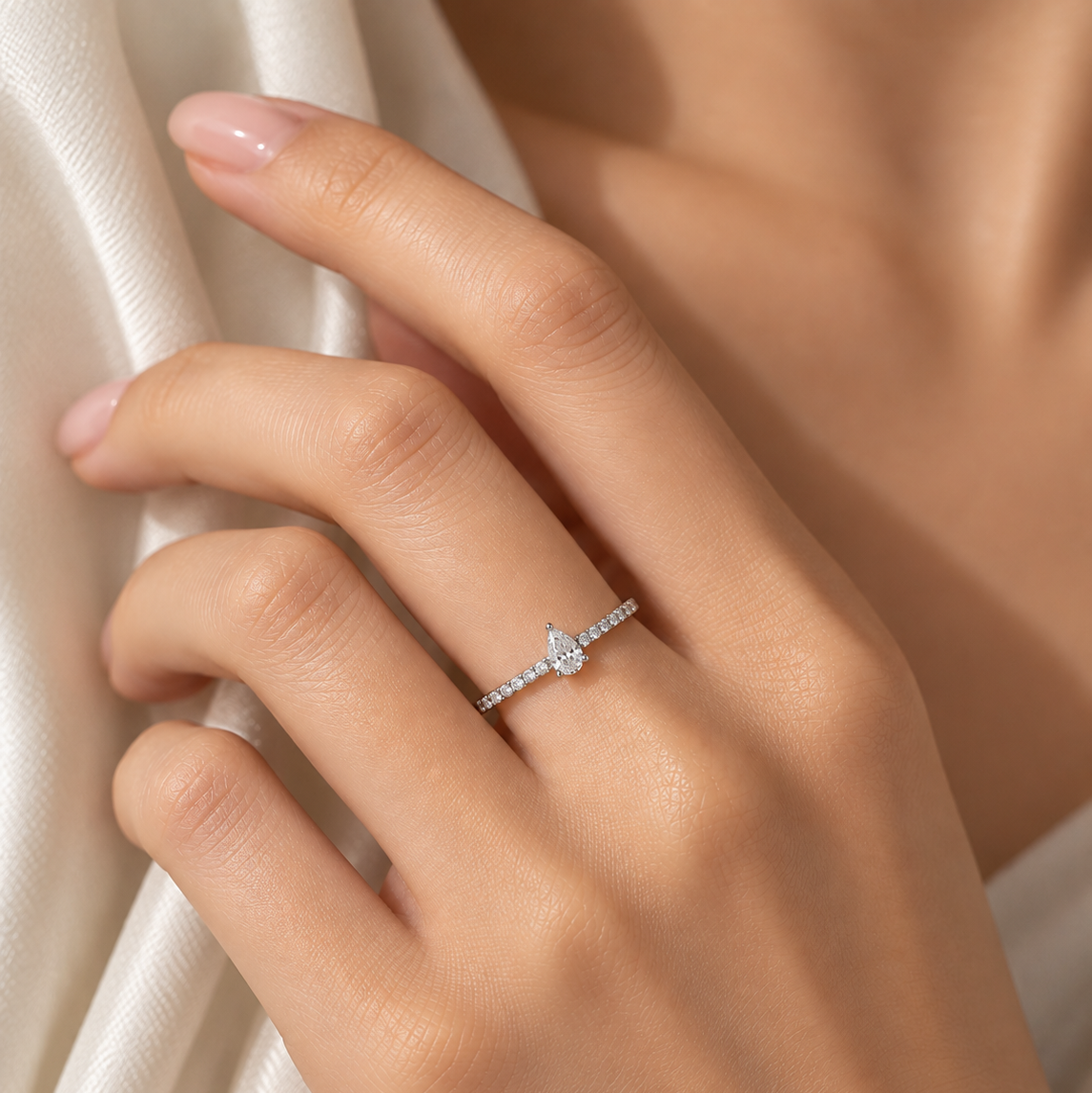 18K white gold natural diamond ring featuring a pear-shaped center diamond with round brilliant-cut diamonds pavé-set along the slim band.
