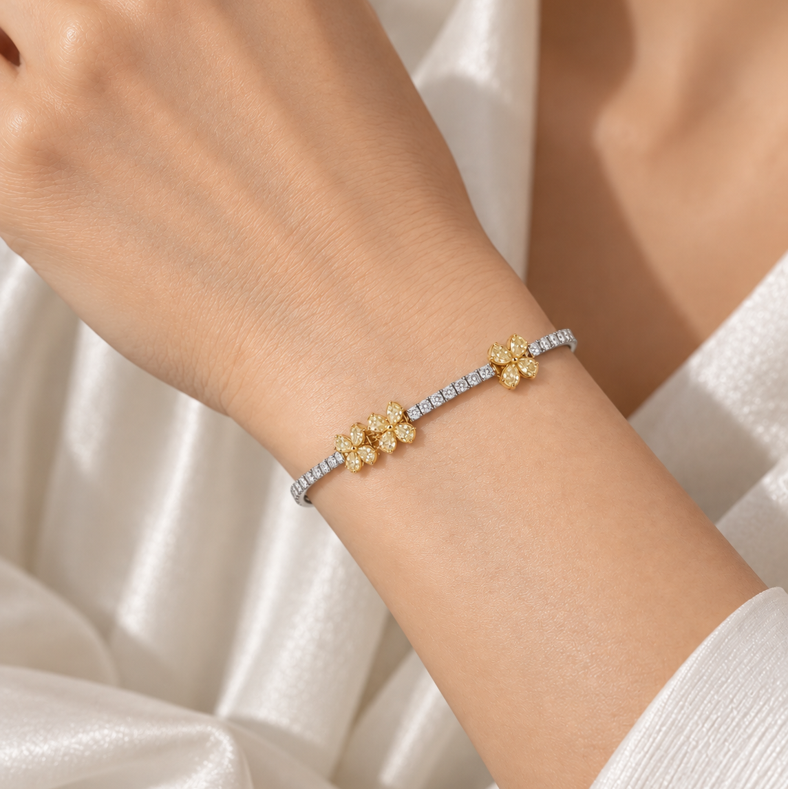 18K gold natural yellow and white diamond bracelet featuring floral clusters of fancy yellow diamonds accented by a sparkling row of round brilliant-cut white diamonds.