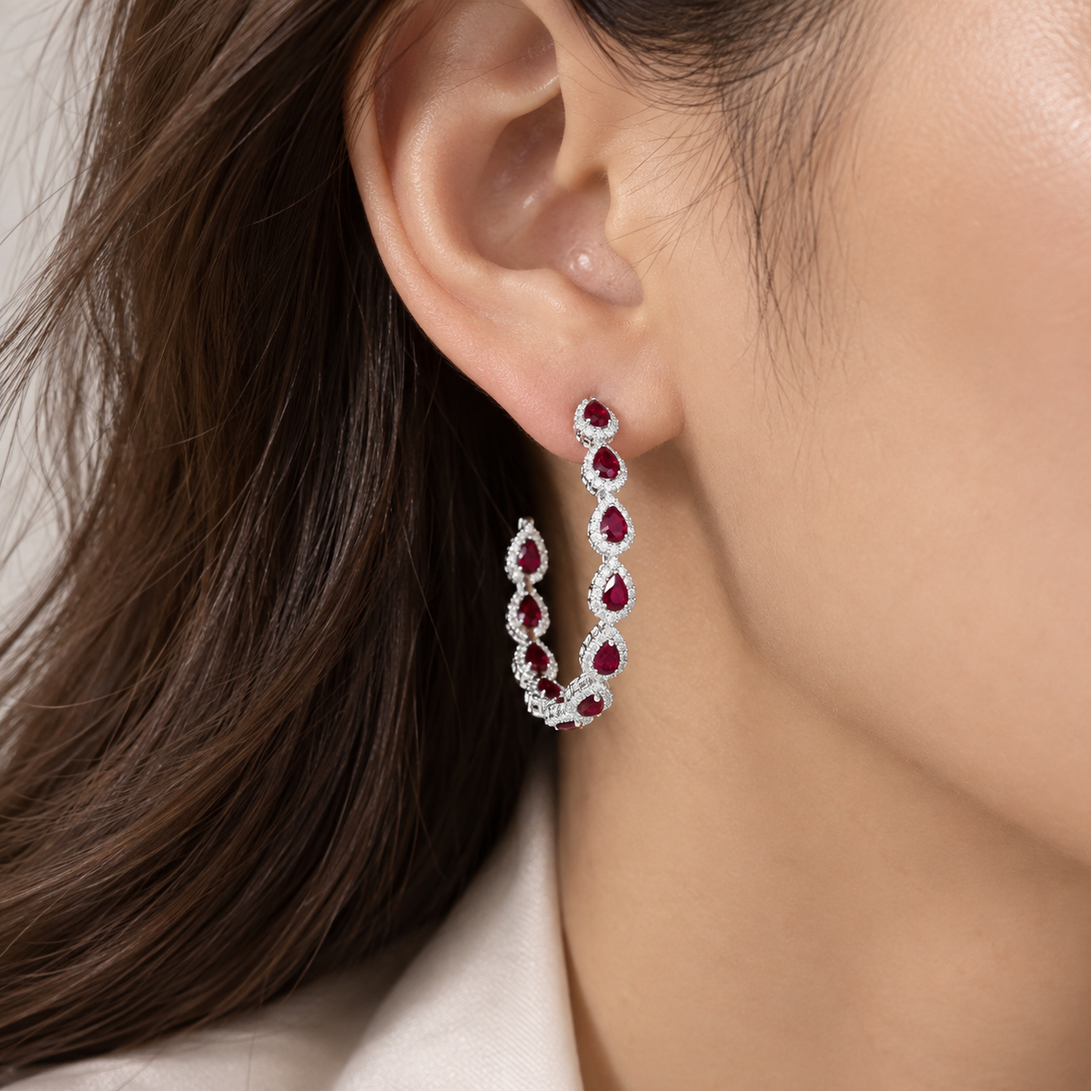 18K gold natural ruby and diamond hoop earrings featuring pear-shaped rubies surrounded by sparkling natural diamond halos in an elegant statement design.
