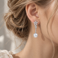 18K white gold natural diamond and pearl drop earrings featuring a floral diamond motif with cascading pavé diamond details and a luminous white pearl.