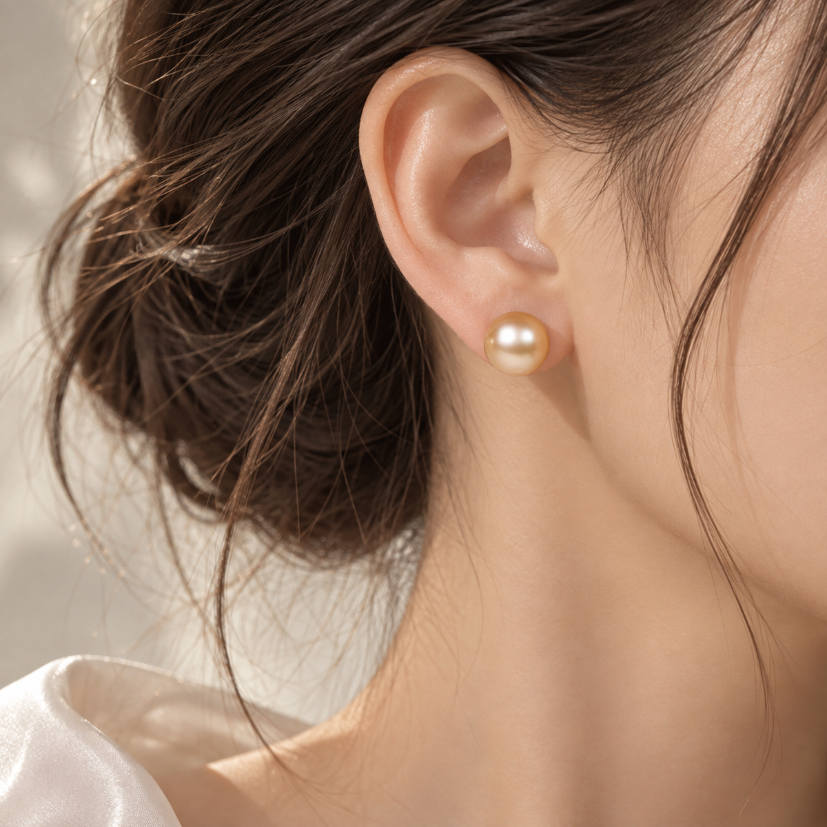 18K gold pearl stud earrings featuring a lustrous golden pearl in a classic minimalist design.