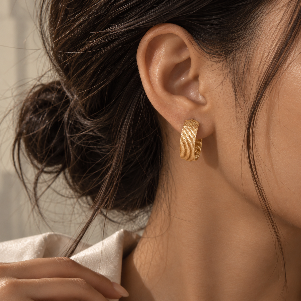 Italian 18K gold hoop earrings featuring a wide textured ribbed design with a bold sculptural silhouette.
