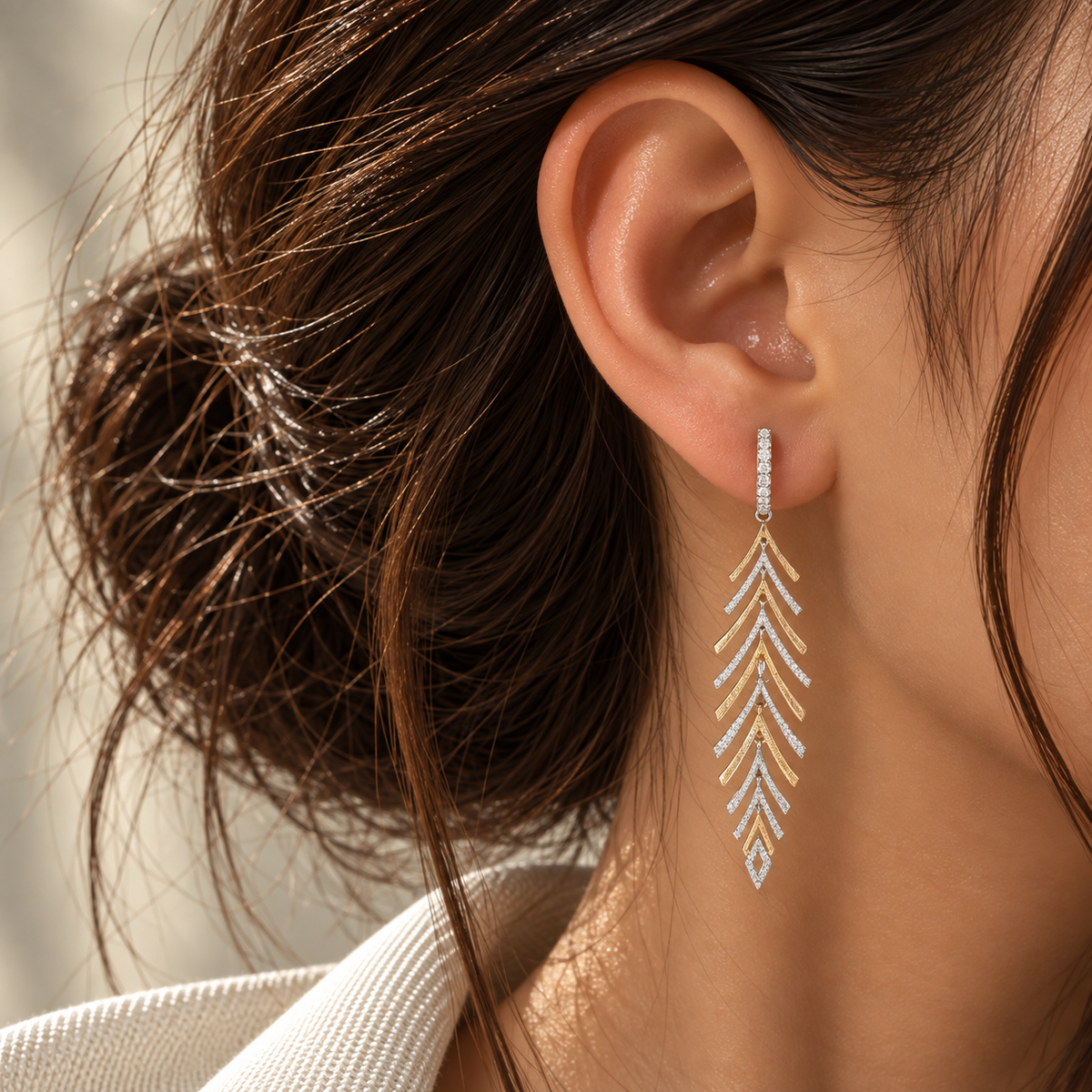 18K two-tone gold natural diamond drop earrings featuring a long feather-inspired geometric design accented with sparkling colorless diamonds.