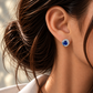 18K white gold Le Grand Bleu stud earrings featuring deep natural blue sapphires accented with a gradient sapphire halo and sparkling natural colorless diamonds in a wave-inspired design, as featured in British Vogue.