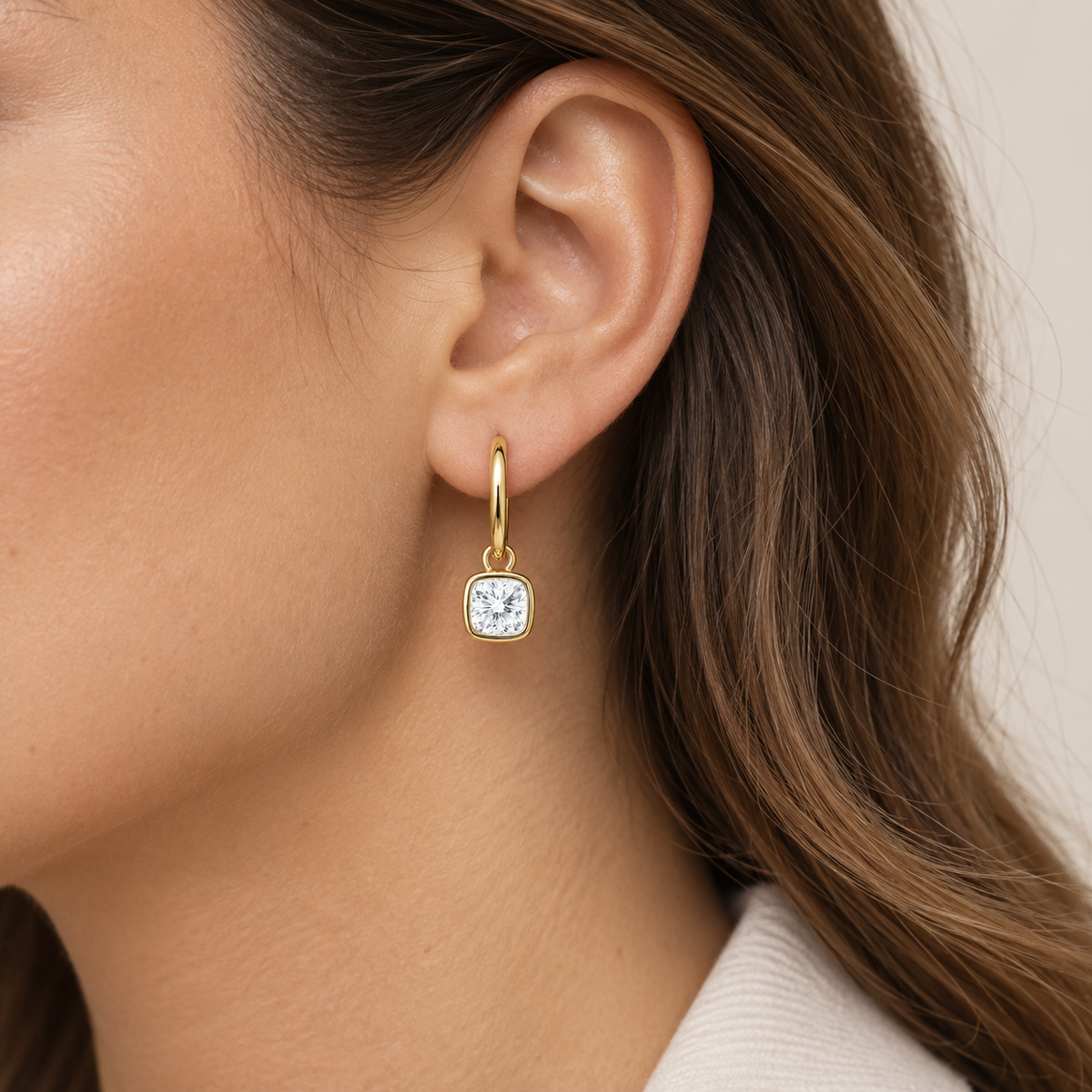 14K gold hoop earrings featuring 1-carat cushion-cut lab-grown diamonds in sleek bezel settings, styled on the ear.