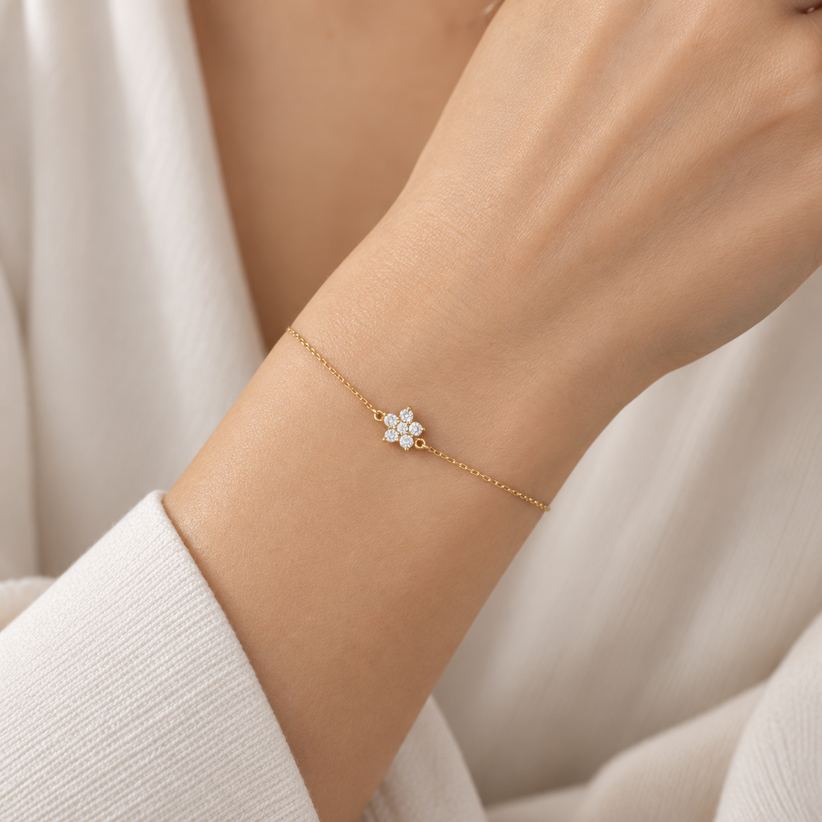 18K gold natural diamond flower bracelet featuring seven round brilliant-cut diamonds arranged in a delicate floral cluster on a fine gold chain.