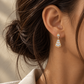 Italian 18K gold drop earrings featuring an elegant fan-shaped design with layered white stone accents and intricate gold detailing.