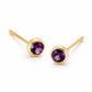 Pair of 18K yellow gold stud earrings featuring bezel-set round purple amethyst gemstones.