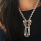 A model wearing a luxurious double-strand Akoya pearl necklace featuring a versatile centerpiece brooch. The intricate brooch in IMG_0810.jpg showcases a 1.16ct ruby surrounded by a diamond halo, flanked by two large pearls, with cascading diamond swags and three Akoya pearl tassel drops.