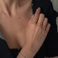 Close-up of a woman modeling an 18K yellow gold open bypass ring with 0.60ctw bezel-set lab-grown diamonds on her index finger.