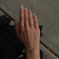 Top-down view of a woman's hand wearing an 18K gold bezel-set lab-grown diamond wrap ring outdoors.