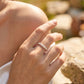 Close-up of a 14K yellow gold lab-grown diamond band on a finger, showing the marquise and round diamond leaf pattern.