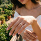 Model wearing a 14K yellow gold marquise and round lab-grown diamond band outdoors in sunlight.