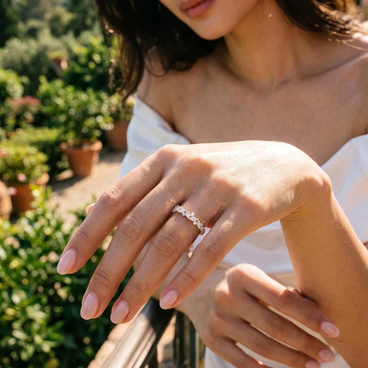 Model wearing a 14K yellow gold marquise and round lab-grown diamond band outdoors in sunlight.