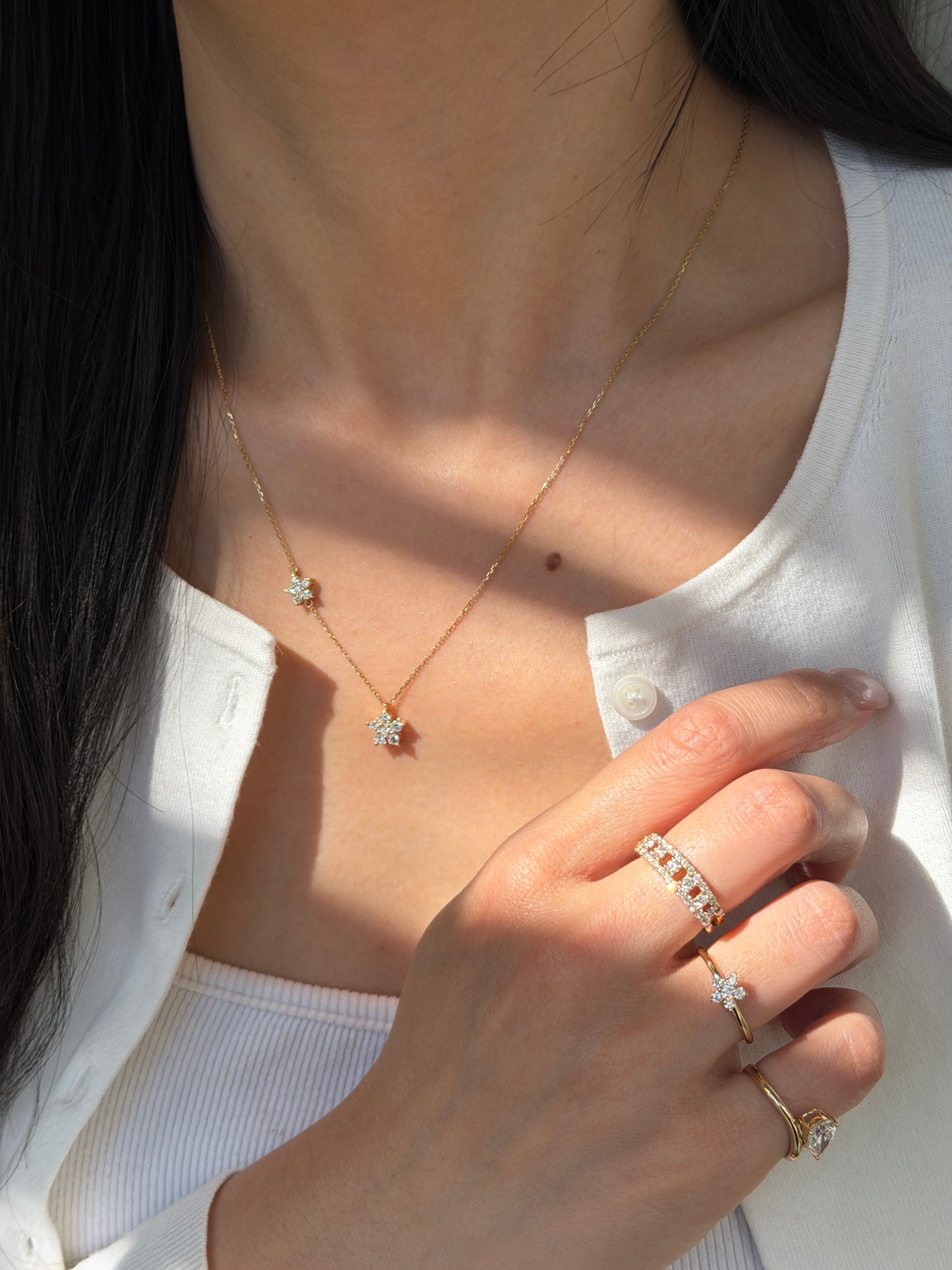 Model wearing the 18K Shimmering Steps Diamond Ring alongside the Duo-Flora Petite Necklace and Floral Ring.