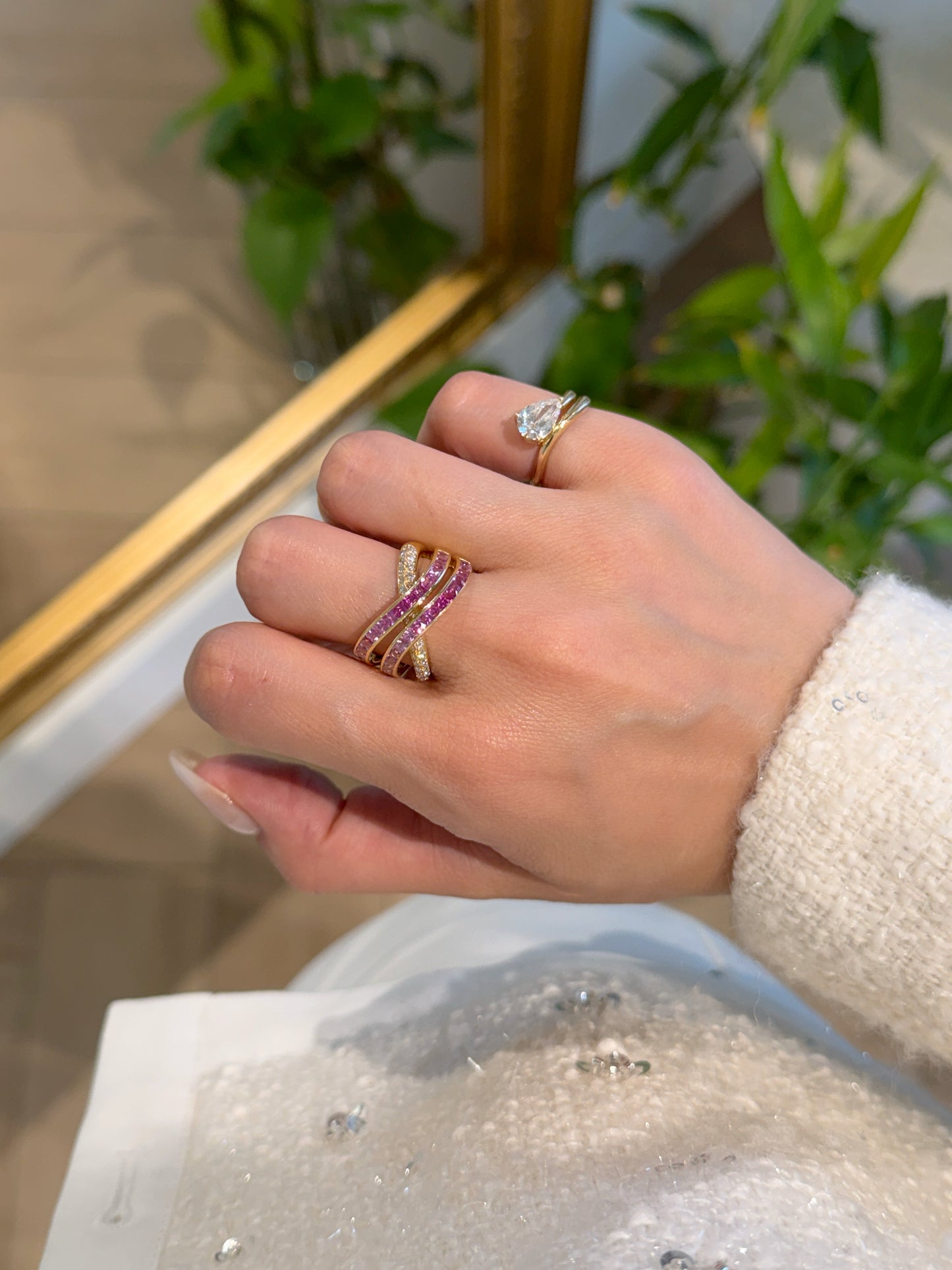 18K yellow gold Azure Tide ring with rows of pink sapphires and shimmering diamonds in a wave-inspired crossover band.
