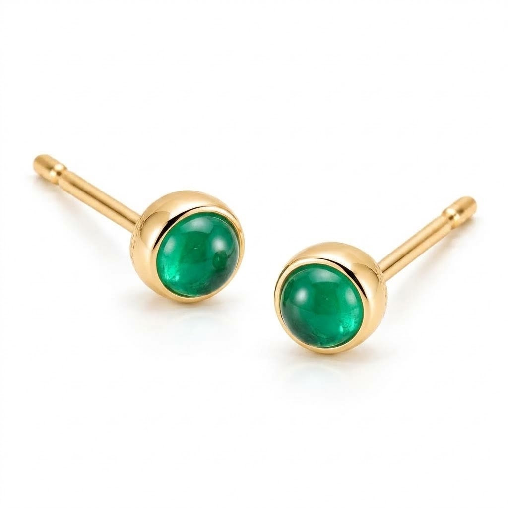 Pair of 18K yellow gold stud earrings featuring bezel-set round green emerald cabochons.