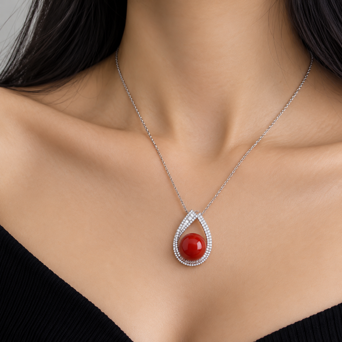 18K white gold pendant necklace featuring a polished natural red coral sphere framed by a teardrop-shaped halo of sparkling natural diamonds.