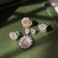 Italian silver floral jewelry collection featuring textured silver petals and gold-tone flower centers, displayed on rich green velvet.
