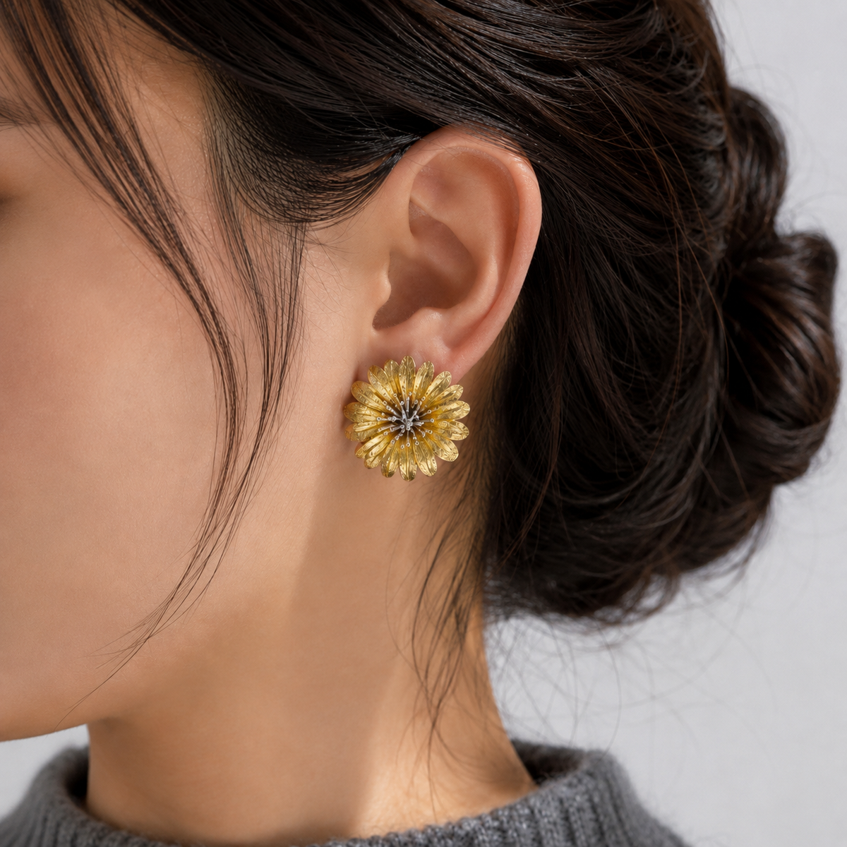 Italian silver floral statement earring with textured gold-tone petals and delicate silver accents, styled on the ear.