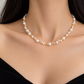 18K yellow gold freshwater pearl necklace featuring lustrous white pearls in graduated sizes, accented with delicate gold beads for an elegant contemporary design.