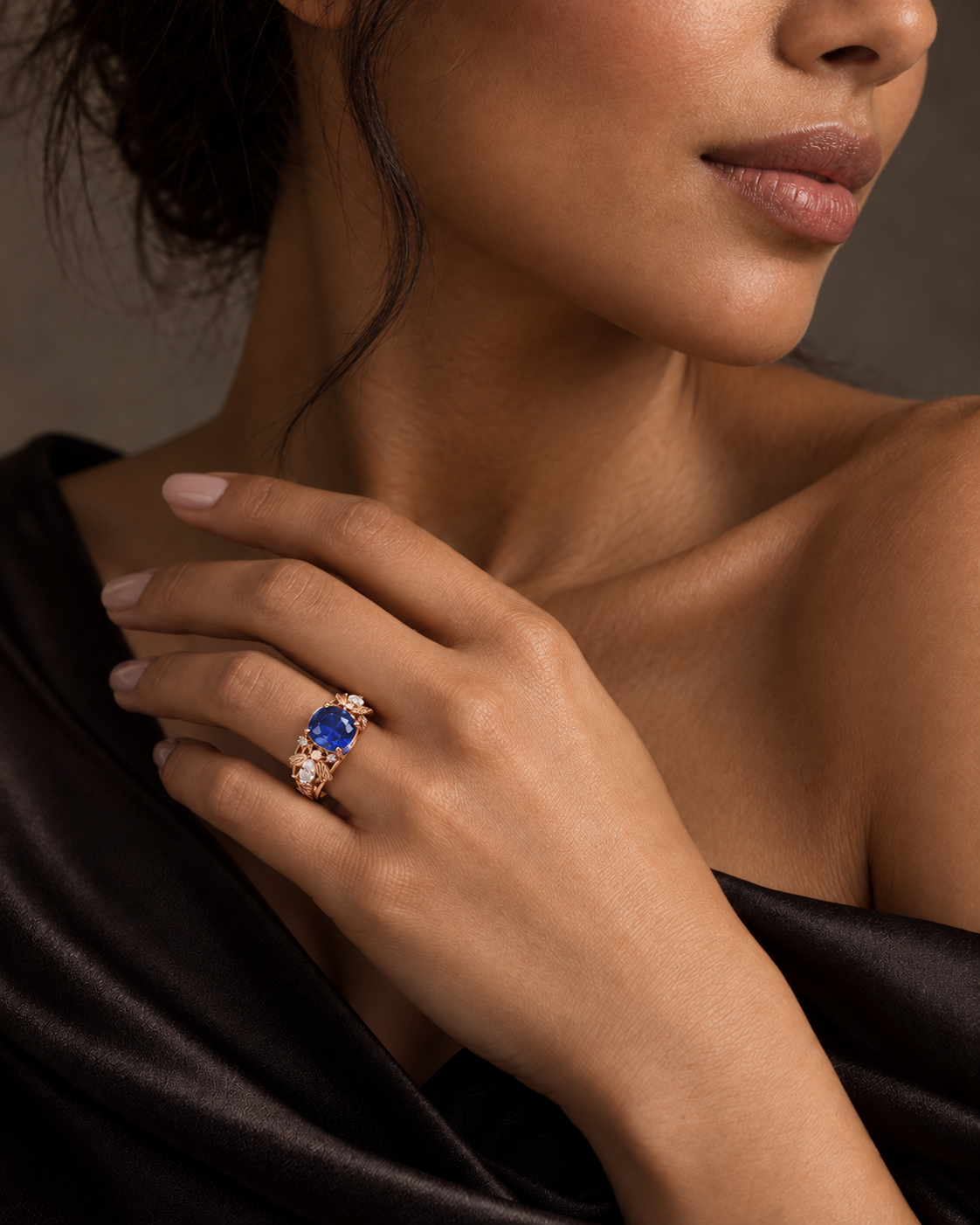 Model wearing a rose gold bee ring with an oval blue sapphire and diamond details by Fantasilvia